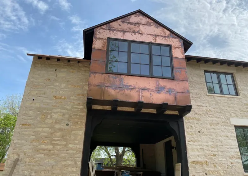 Copper metal panel facade on a stone building for Skylight Installation in Spring Ridge